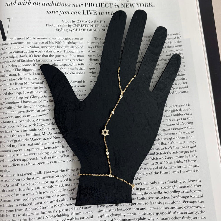 Sterling silver Star of David hand chain displayed on a jewelry hand stand with sparkling cubic zirconia accents.