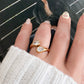 Hand wearing the Suzana Ring, a gold open ring with two sparkling pear-cut crystals
Image Title: Suzana Ring Styled on Hand