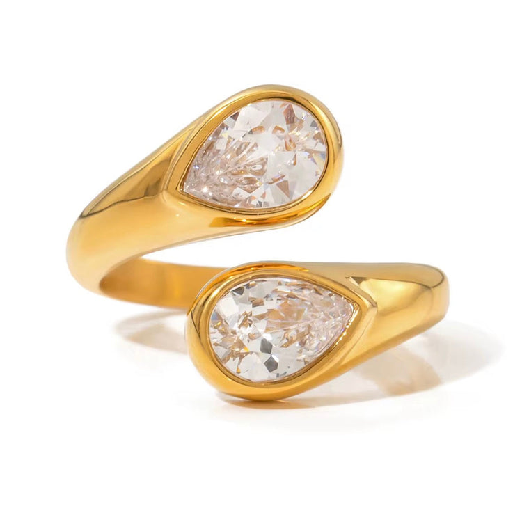 Suzana Ring gold open band with two pear-cut clear crystals on a white background