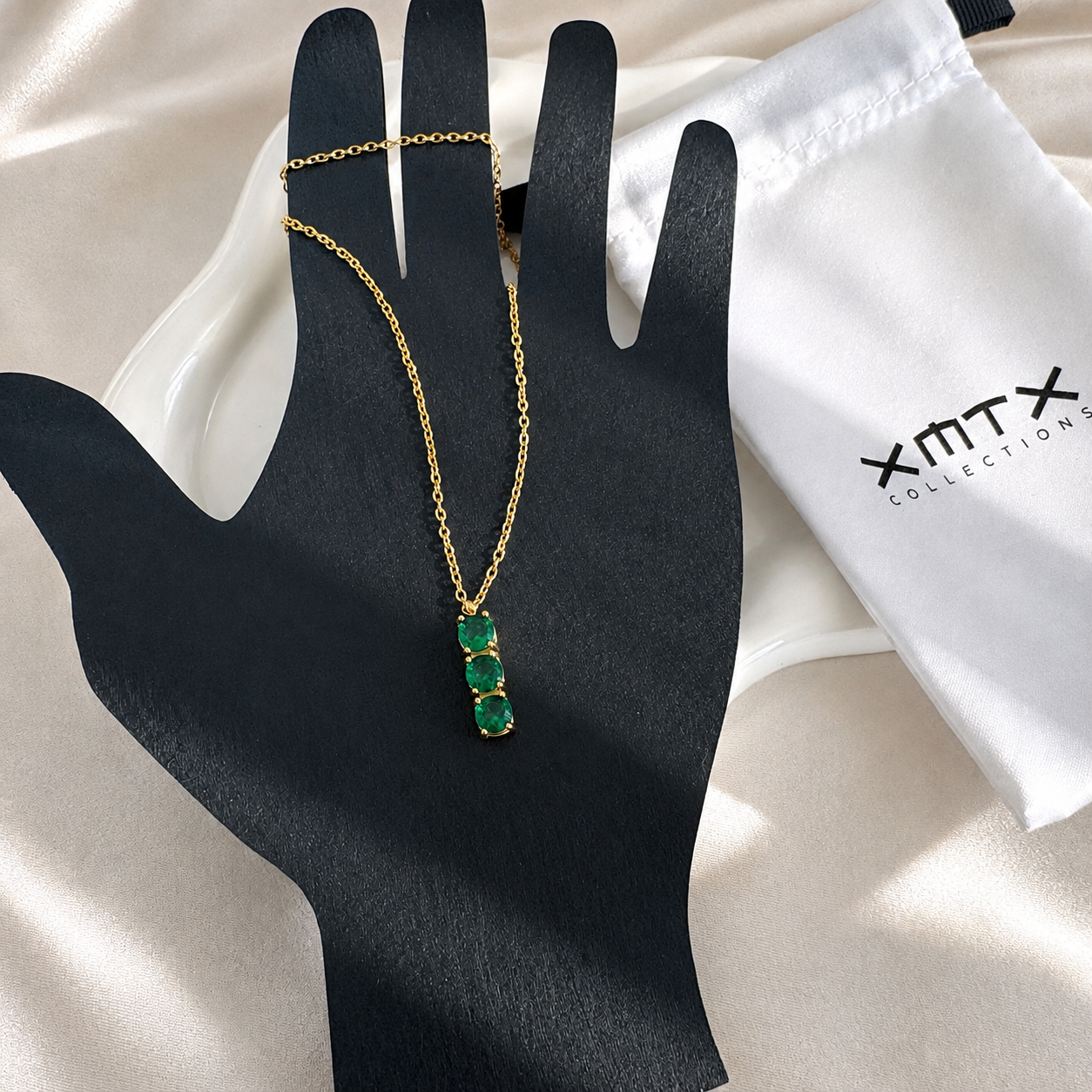 Three Green Stones Necklace displayed on a black jewelry hand showing the vertical green stone pendant