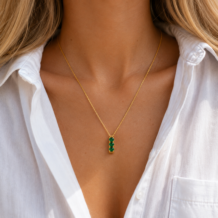 three Green Stones Necklace with three green zircon stones on a gold chain worn on a model