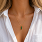 three Green Stones Necklace with three green zircon stones on a gold chain worn on a model