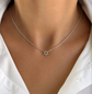Dainty sterling silver Star of David necklace worn on a model, featuring a tiny pavé pendant on a 14-inch chain.