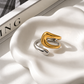 two Tone Open Ring displayed on a white jewelry dish showing its polished gold and silver finish