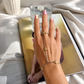 Woman wearing the Two Tone Starfish Ring Hand Chain with an adjustable ring and waterproof mixed-metal starfish design