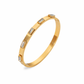 Gold Abby bangle bracelet with five clear baguette stones on a white background