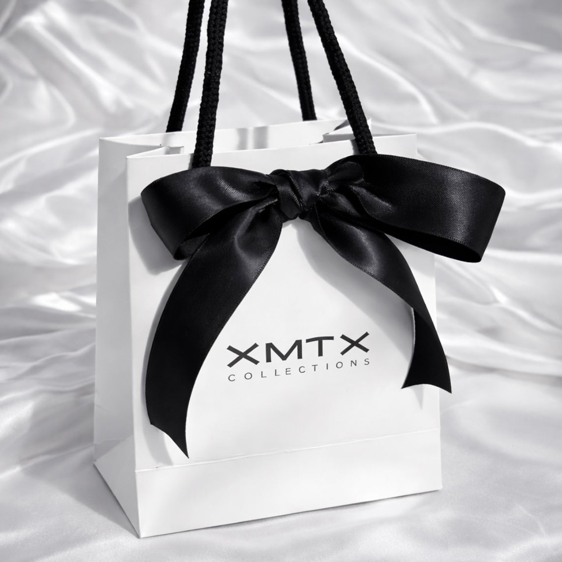 XMTX Collections signature white gift bag with black rope handles and logo, luxury jewelry packaging front view
