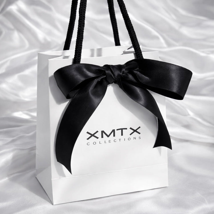 XMTX Collections signature white gift bag with black rope handles and logo, luxury jewelry packaging front view
