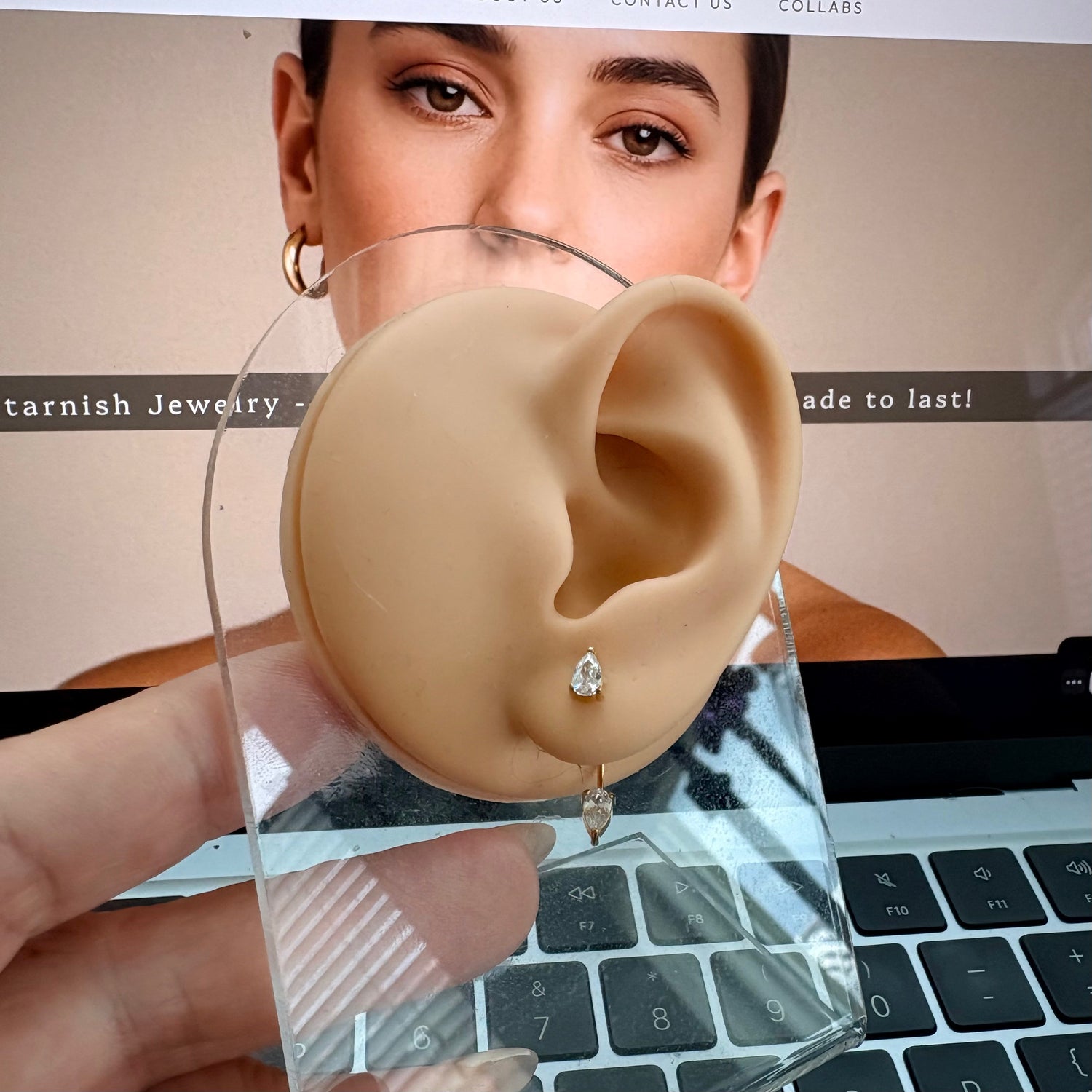 Pear ear jacket earrings worn on ear with small front stud and drop peeking from underneath lobe
