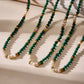 Multiple malachite and freshwater pearl necklaces displayed with gold accents and natural stones